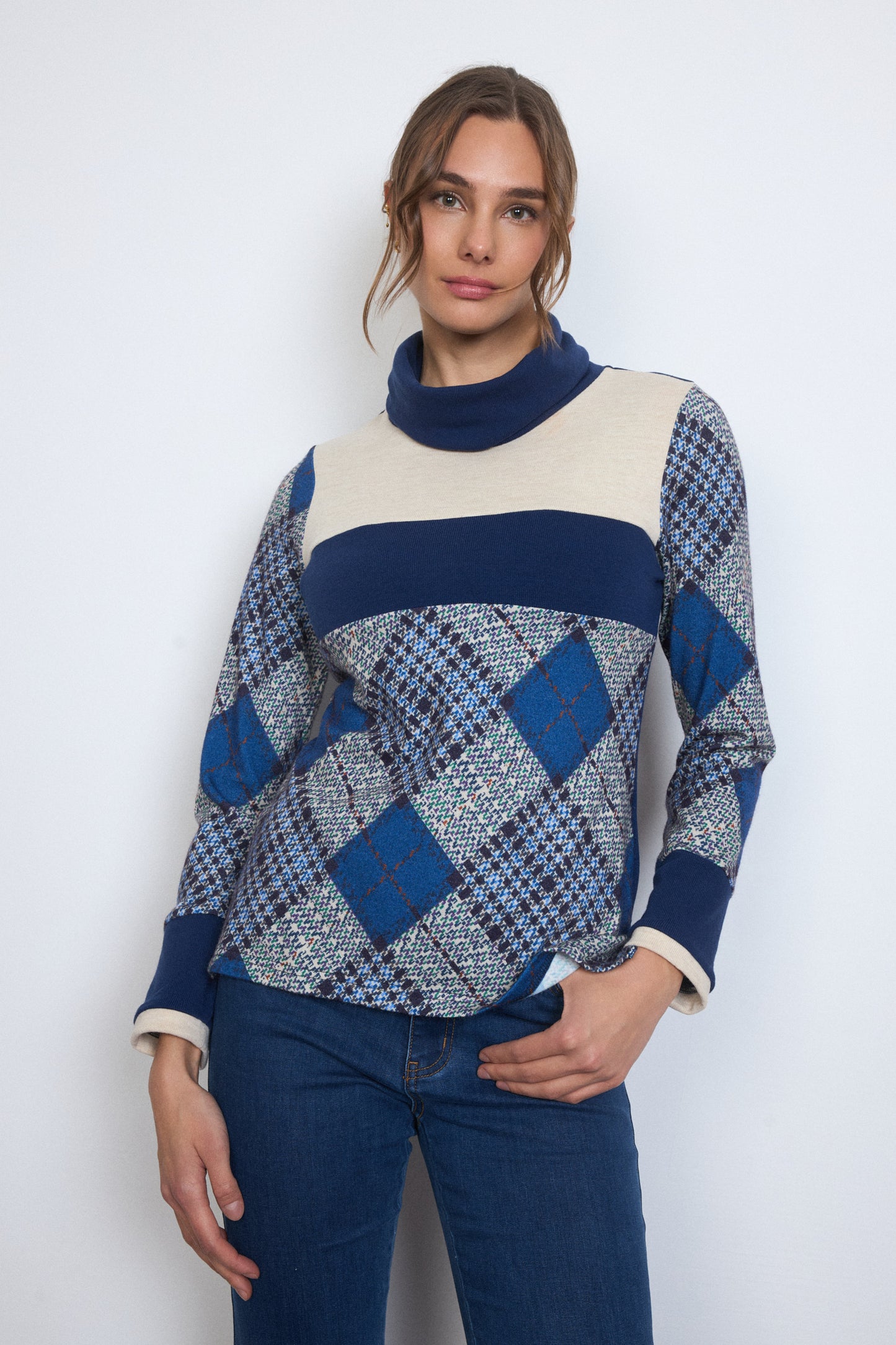 Woman wearing a blue and white patterned sweater against a white background
