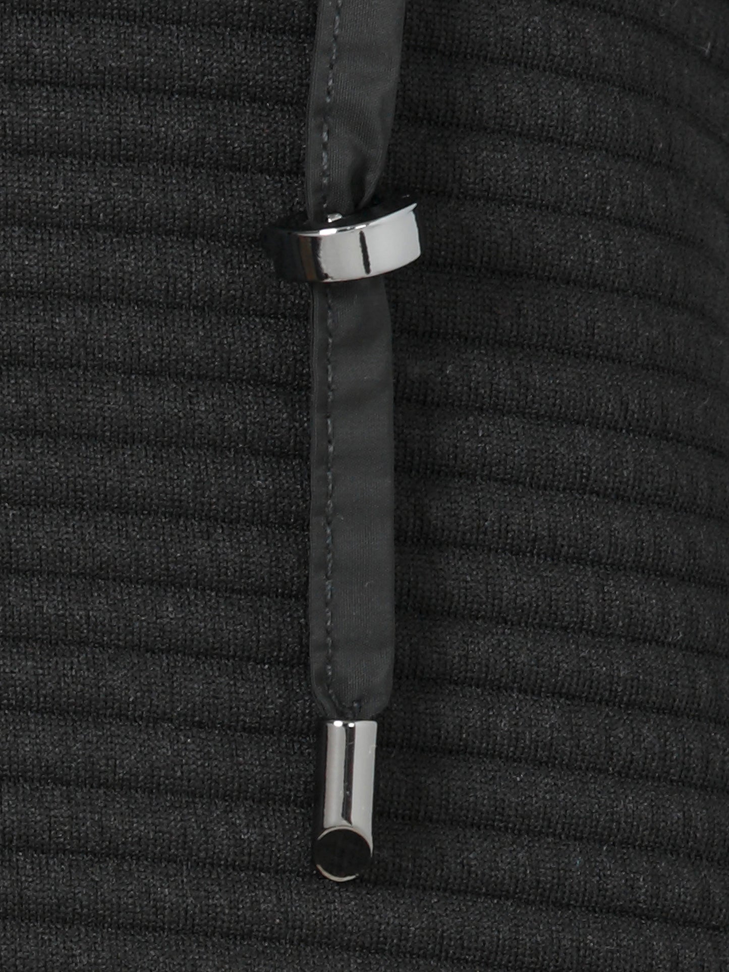Close-up of a black textured fabric with silver metal rings on a matching background