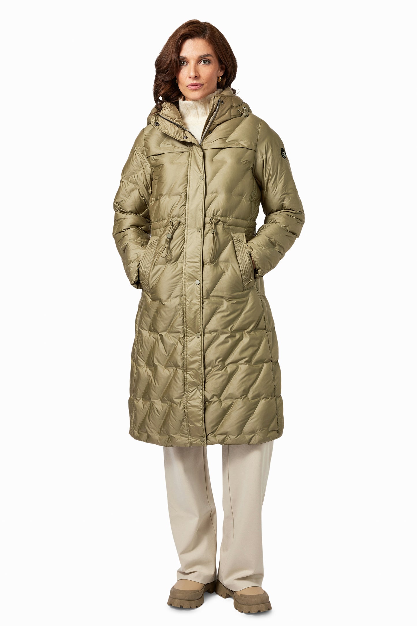 Woman wearing a long quilted beige coat on a white background