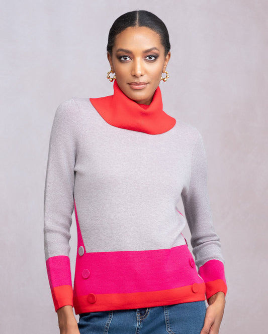 Woman wearing a gray sweater with red and pink accents on a gray background
