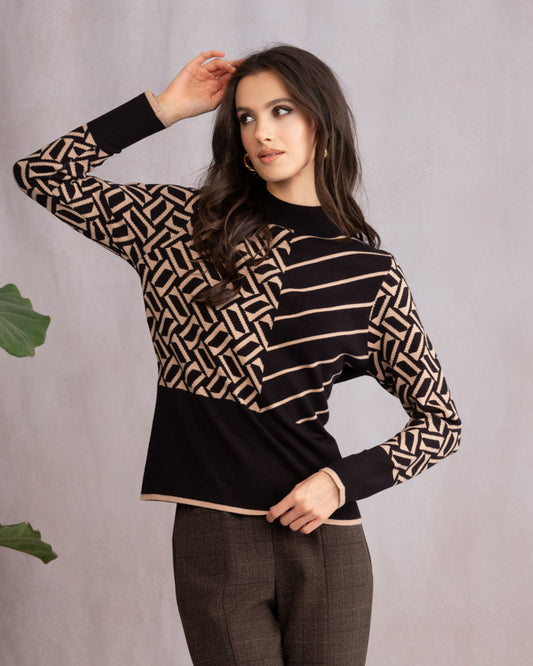 Woman wearing a black and beige patterned sweater against a gray background