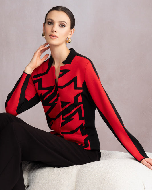 Woman wearing a red and black patterned sweater against a neutral background