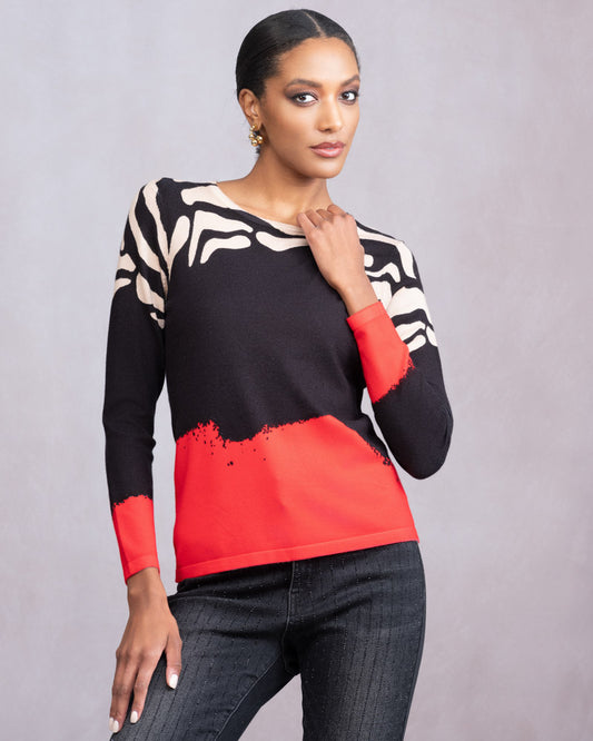 Woman wearing a black, white, and red patterned top against a gray background