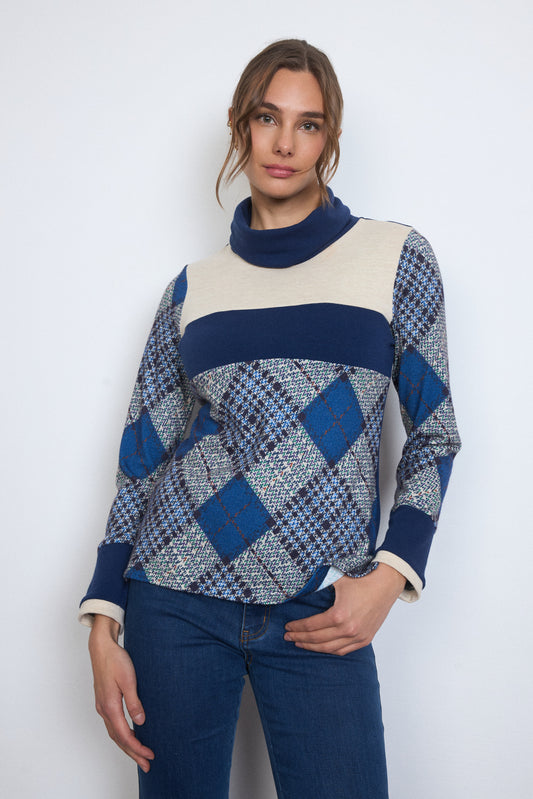 Woman wearing a blue and white patterned sweater against a white background