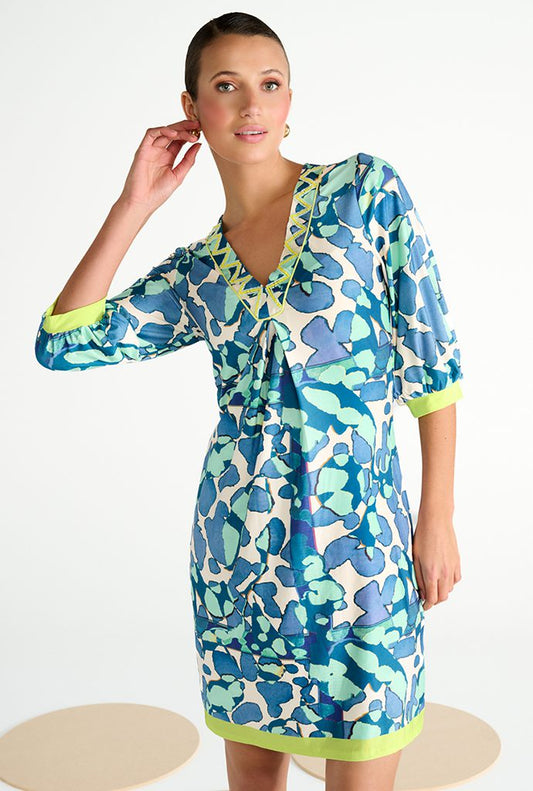 Woman wearing a blue and green patterned dress on a white background