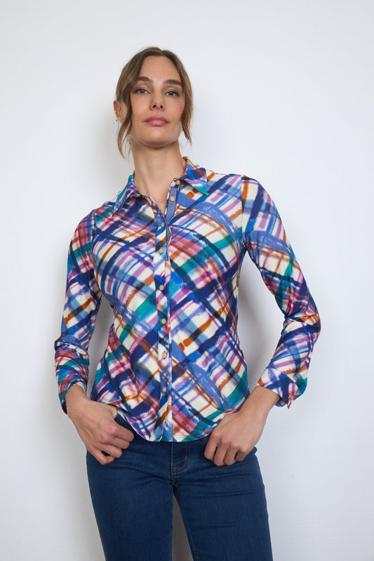 Woman wearing a colorful plaid shirt against a white background