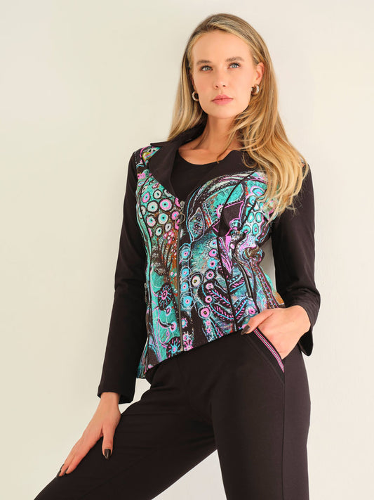 Woman wearing a black top with a colorful patterned vest against a plain background