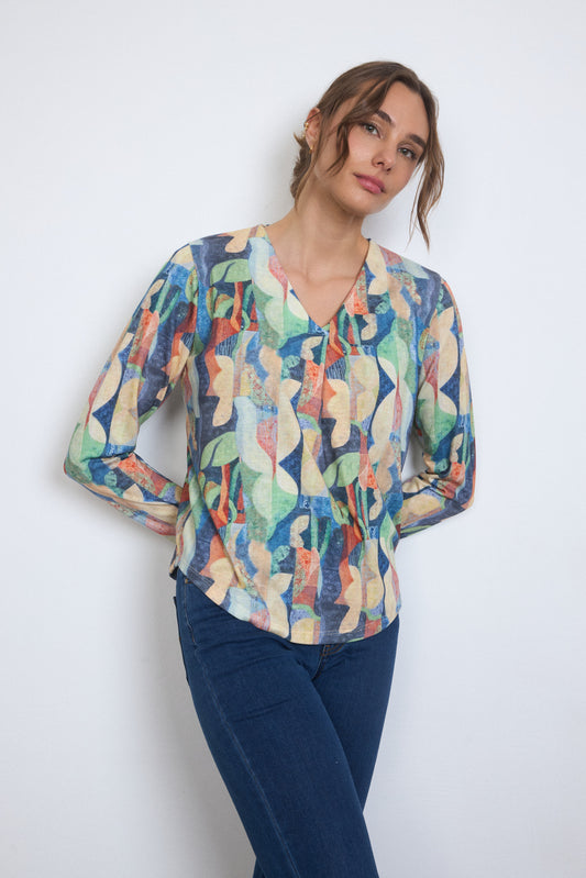 Woman wearing a colorful patterned blouse against a white background