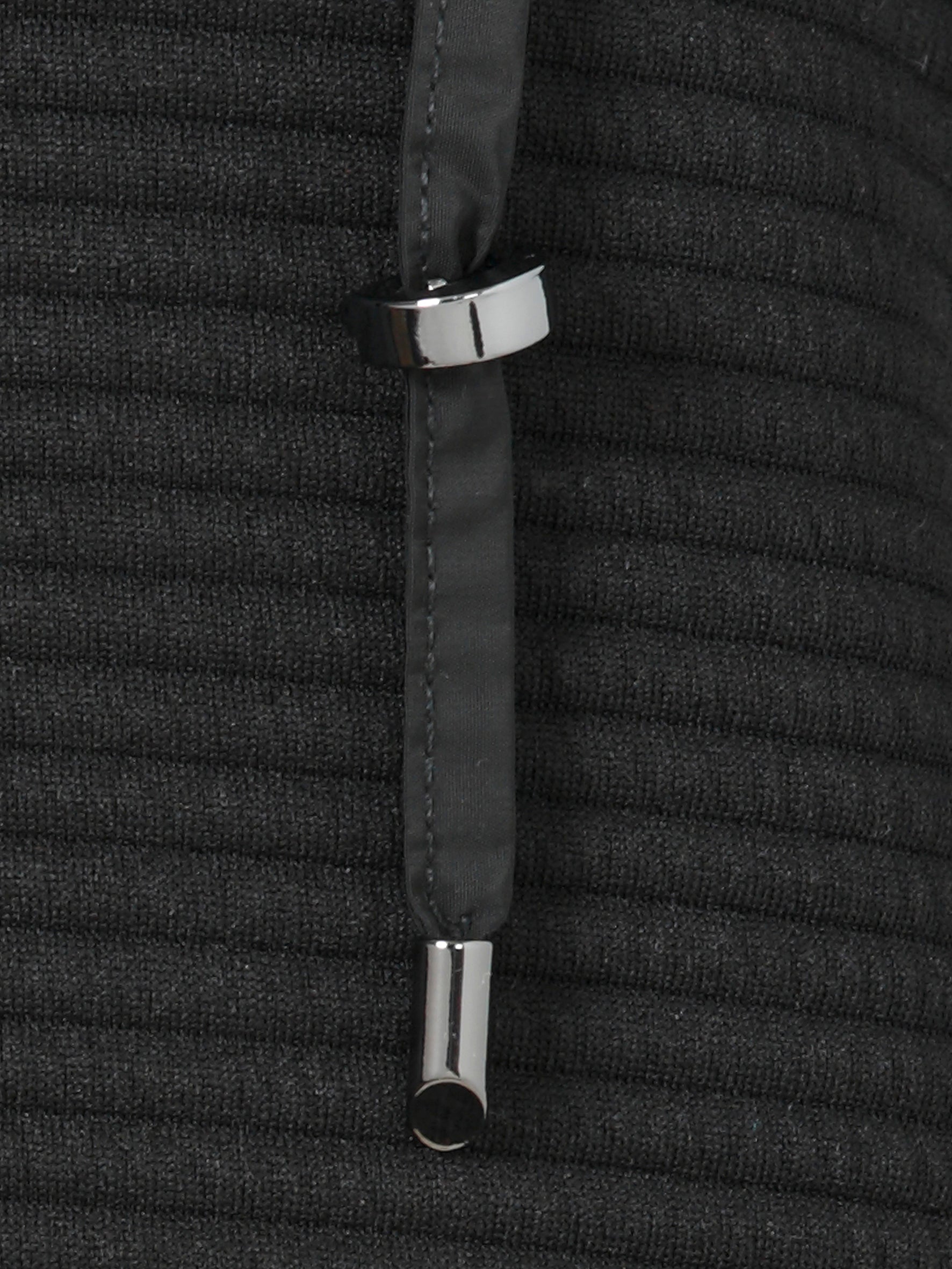 Close-up of a black textured fabric with silver metal rings on a matching background