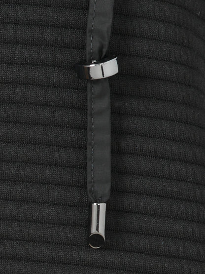 Close-up of a black textured fabric with silver metal rings on a matching background